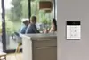 Ein Wandbedienfeld mit mehreren Tasten und einem digitalen Display, das zur Steuerung von Smart-Home-Geräten dient.